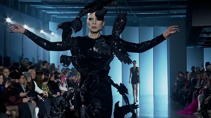 Una modelo alza el vuelo con una creación inspirada en un cuervo en el desfile de alta costura cósmica de Rahul Mishra en París.