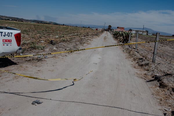 La cinta amarilla de la policía bloquea un polvoriento camino de tierra.