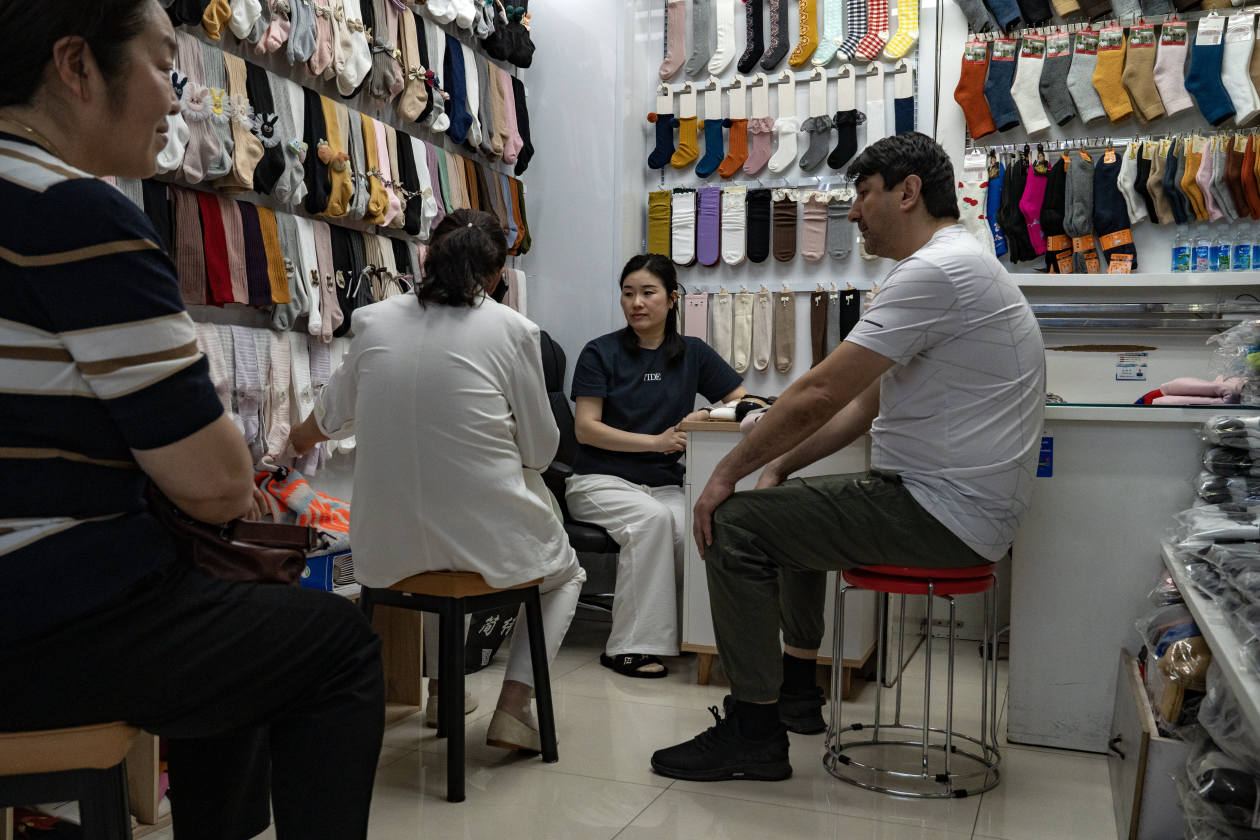 Un comprador extranjero negocia con el dueño de una tienda en un mercado de calcetines en Yiwu, China.