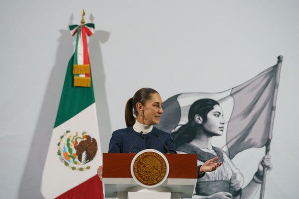 La presidenta de México, Claudia Sheinbaum, hablaba junto a una bandera.