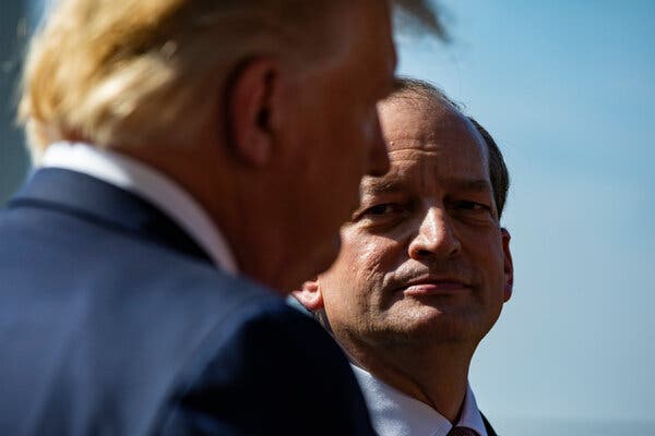Un primer plano de Alexander Acosta mientras mira hacia Donald Trump