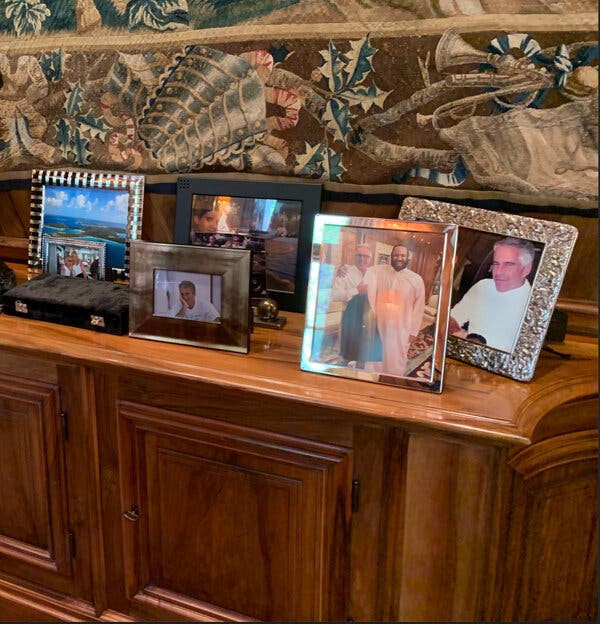 Un aparador con diversas fotos enmarcadas de Epstein, solo y con otras personas.