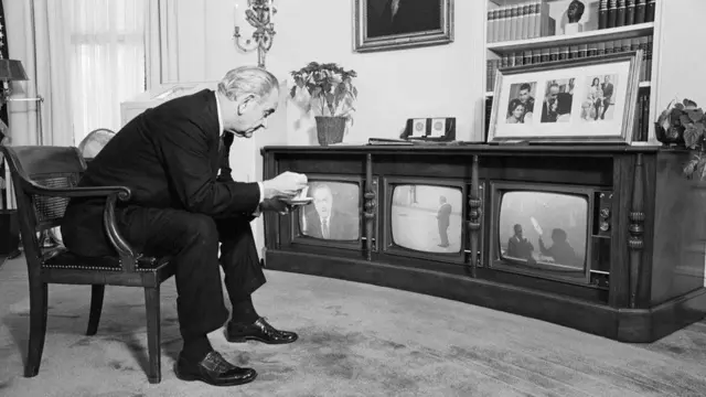 Lyndon Johnson viendo la misión Apolo 8 en tres televisores.