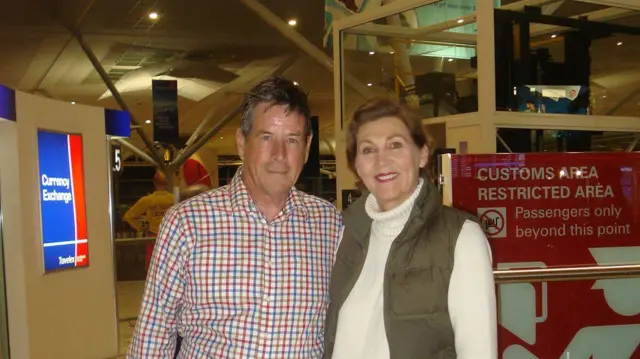 Peter y Margaret en el aeropuerto sonríen a la cámara